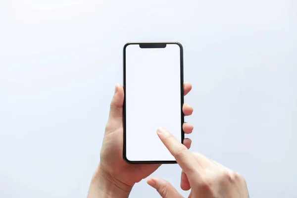 Akıllı telefon maketi. Siyah telefon beyaz ekranını tutarak elinizi kapatın. Beyaz arka planda izole edilmiş. Cep telefonu çerçevesiz tasarım kavramı.