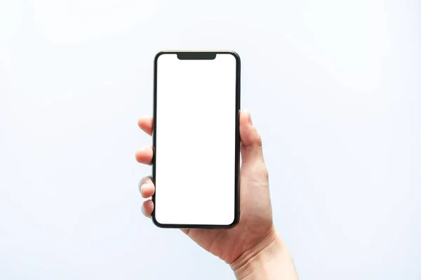 Akıllı telefon maketi. Siyah telefon beyaz ekranını tutarak elinizi kapatın. Beyaz arka planda izole edilmiş. Cep telefonu çerçevesiz tasarım kavramı.