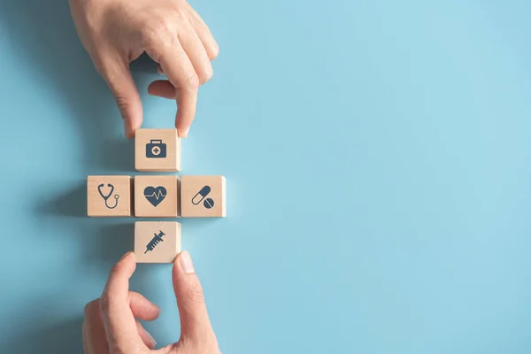 Ziektekostenverzekering Concept Twee Handen Rangschikkend Houten Kubus Met Medisch Symbool — Stockfoto