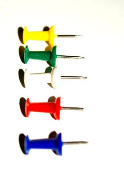 Beyaz arkaplanda izole edilmiş farklı renklerde raptiye ve ataçları it.