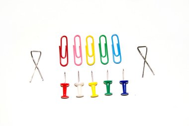 Beyaz arkaplanda izole edilmiş farklı renklerde raptiye ve ataçları it.