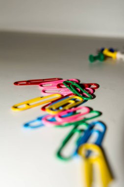 Beyaz arkaplanda izole edilmiş farklı renklerde raptiye ve ataçları it.