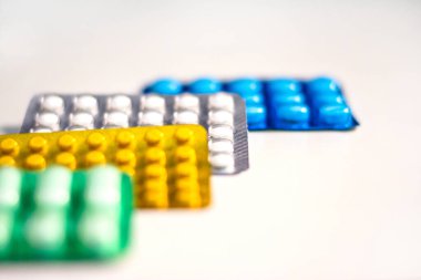 Renkli bir sürü hap ve tablet beyaz arka planda izole edilmiş, ilaç antibiyotik ilaç kapsülü hapları pakette.