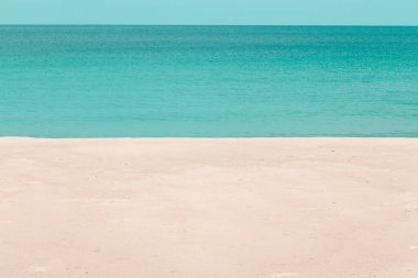 Güneşli bir günde beyaz kumlu sahil ve turkuaz deniz suyu