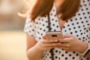 Akıllı bantlara cep telefonu bağlantısı kullanan yakın plan genç kadın.