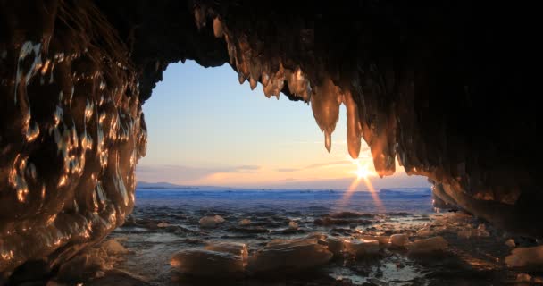 Winter Bajkal. Ledová jeskyně s rampouchy při západu slunce — Stock video
