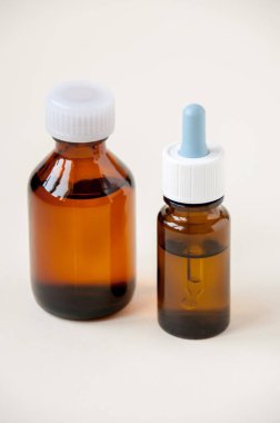 İki şişe koyu cam sıvı ilaç.