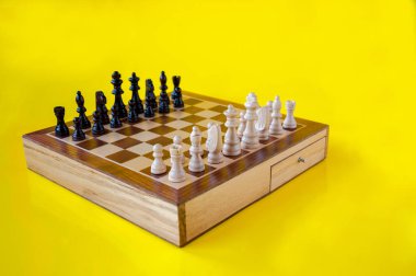 Sarı arkaplanda tahta satranç tahtası