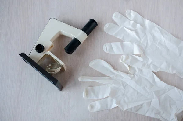 Still life : Microscope and disposable gloves on the table