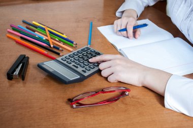 Öğrenci hesap makinesine güvenir ve deftere yazar