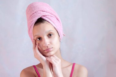 Hafif arka planda pembe havlusu olan kız.