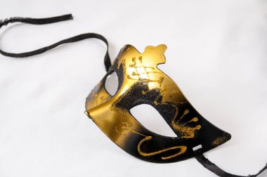 Açık arkaplanda siyah ve altın maskeli bir karnaval. Tiyatro günü