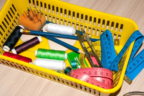 On the table is a basket of tools for sewing