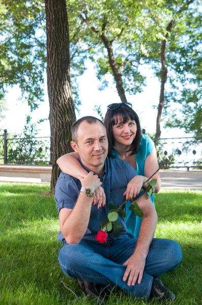 Bir kadın ve orta yaşlı bir adam çimlerde dinleniyor.