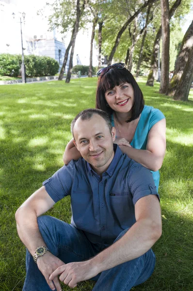 Aile adamı ve kadın parkta dinleniyor.