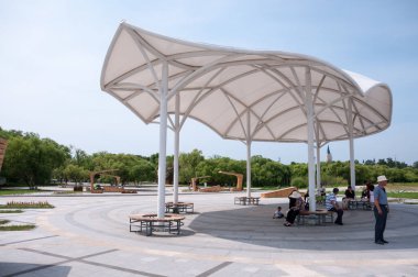 Çin, Heihe, Temmuz 2019: Yazın Heihe şehrindeki toprak setin üzerindeki parktaki güneşten çatı