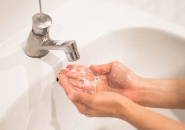 Coronavirus koruması için akan su ve sabunla elini yıkayan kadın salgını durdurmak için hijyen..