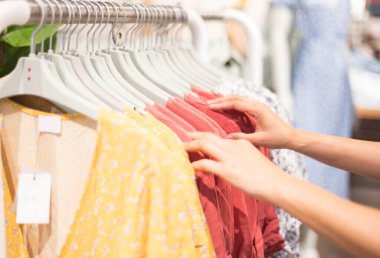 Kumaş mağazasındaki kumaş mağazasının rafında işaretlenmiş pamuk elbise için kıyafet seçen kadın eli. Giyim ürünlerinin fiyatını, indirimini ve tanıtımını kontrol et.