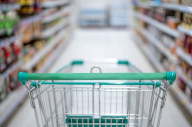 Süpermarket koridorunda boş gümüş ve yeşil alışveriş arabasıyla bulanık etki, Süpermarkette yiyecek istiflemek için Panik Alıcı, Coronavirus Covid-19 konsepti,.