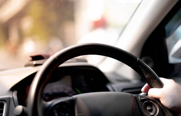 close up of female Hands of a driver on steering wheel of a inside a car  on the road.