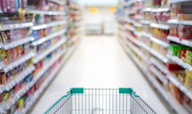 Süpermarket koridorunda boş gümüş ve yeşil alışveriş arabasıyla bulanık etki, Süpermarkette yiyecek istiflemek için Panik Alıcı, Coronavirus Covid-19 konsepti,.