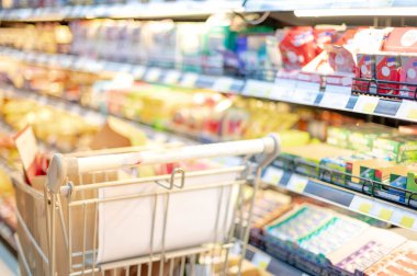 Süpermarket koridorunda gümüş ve yeşil alışveriş tramvayı ile bulanık etki, Süpermarkette yiyecek istiflemek için Panik Alıcı, Coronavirus Covid-19 konsepti.