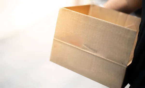 物流配送のための段ボール箱包装を運ぶ配達人の手 — ストック写真