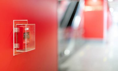 The red fire alarm switch on the wall at the Bangkok subway.	