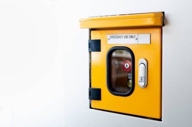 Fire extinguisher and fire hose reel on the white wall at the Bangkok subway.	