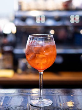 Aperol alkollü bir kokteyl. Turuncu. Buz küplü soğuk içecek. Bardak barın üstünde. Sıcak hava için taze kokteyl. Restoranlar, kafeler ve barlar için menü.