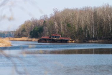 Pripyat hayalet kasabasında yarı batık bir gemi, kıyamet sonrası şehir, Çernobil sınırlama bölgesinde bahar mevsimi, Ukrayna