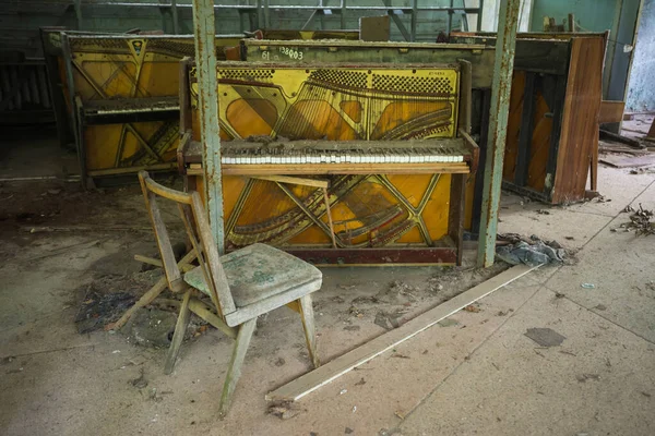 Abandoned furniture store with pianos in ghost town Pripyat, post apocalyptic interior, Chernobyl zone, Ukraine