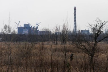Ufuktaki Çernobil Nükleer Santrali 'nin bitmemiş binasının görüntüsü terk edilmiş ve Çernobil Bölgesi' nde kıyametin koptuğu yer.