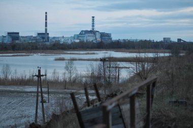 Ufukta Çernobil Nükleer Santrali görünüyor. Terk edilmiş ve kıyamet sonrası manzara, Çernobil Bölgesi 'nde ilkbahar.