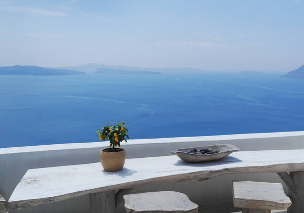 Натюрморт с апельсиновым деревом на столе на фоне моря в Греции Санторини
