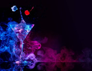 Mavi ve mor dumanlı arka planda martini kokteyli
