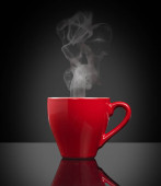 červený šálek horké kávy na černém pozadí