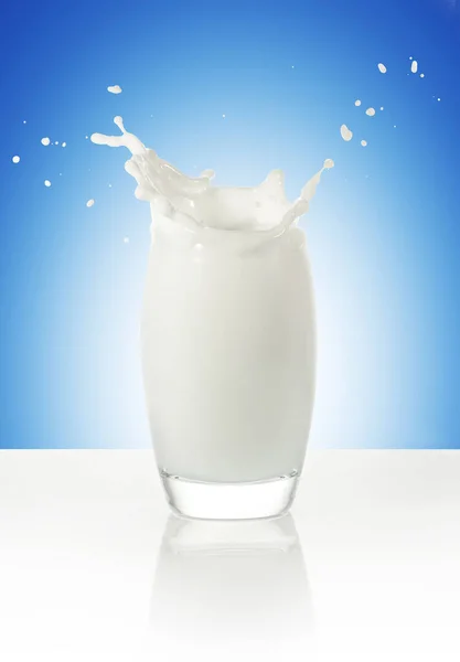 Mjölk Stänk Ett Glas Isolerad Blå Bakgrund — Stockfoto