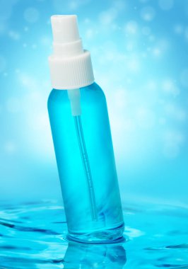 Su dalgasında mavi sıvıyla sprey şişesi