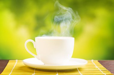 Bulanık yeşil arka planda sıcak bir içecek.