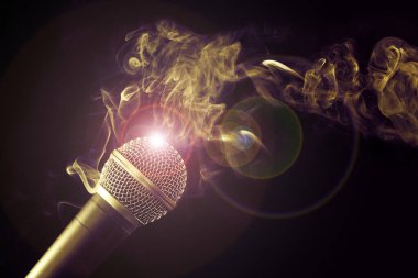 Siyah arkaplanda mikrofon ve duman girdabı