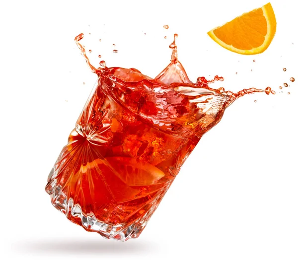 Portakal dilimi, beyaz arkaplana yatırılmış negroni 'nin içine düşüyor.