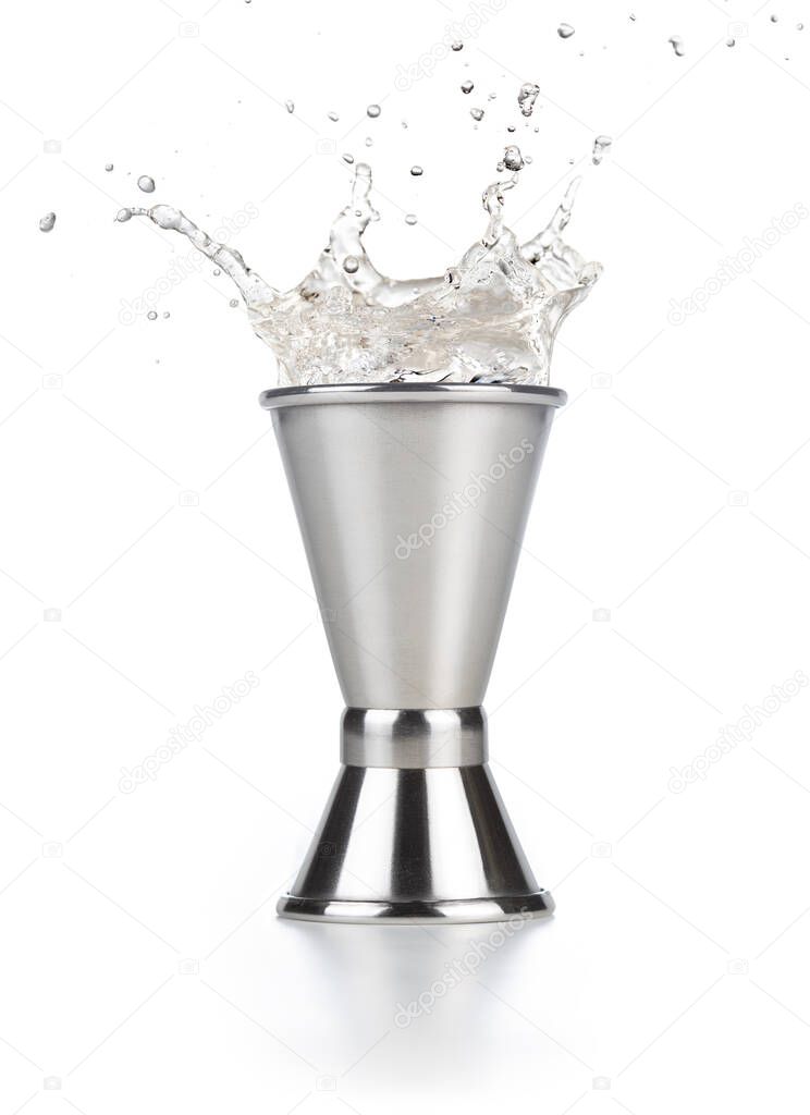 alcohol splashing out of a steel jigger isolated on white