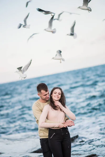 Sirályok repülnek át gyönyörű boldog fiatal pár felett. — Stock Fotó