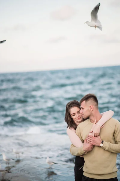 Sirályok repülnek át gyönyörű boldog fiatal pár felett. — Stock Fotó