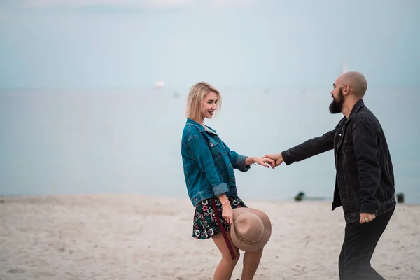 Gelukkig jong stel veel plezier op het strand, hand in hand. — Stockfoto