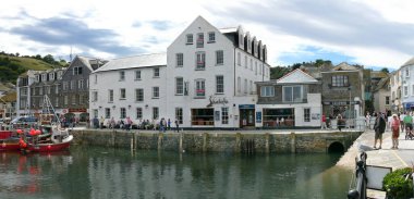 17 Temmuz 2008, Mevagissey, Cornwall, İngiltere. Turistler, iç limanın batı yakasında sıcak bir günde yürürler. Sol tarafta az sayıda yelkenli ve motorlu tekne birbirine yakın demirlemiş.