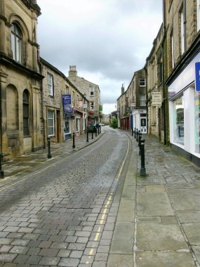 02 Sep 2007: Skipton, North Yorkshire, İngiltere 'de terk edilmiş bir Otley Caddesi. Pek çok küçük işletme kapanmış gibi görünürken, sol taraftaki pencereden bakan iki kişi görülebilir.