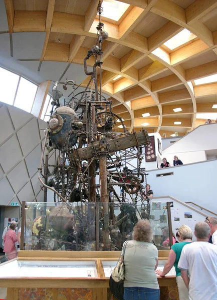 17 Temmuz 2008, The Core, The Eden Project, Cornwall, İngiltere. Bir kapalı sergi arenası altında, turistler meraklı bir şekilde 10 ton, 30 feet yüksekliğindeki Fabrika İşlemcisi olarak bilinen bir mekanizmanın etrafında toplanıyorlar.