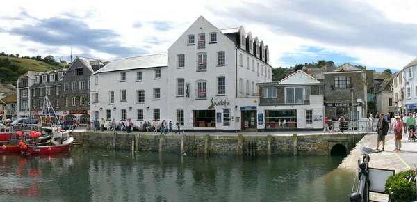 17 Temmuz 2008, Mevagissey, Cornwall, İngiltere. Turistler, iç limanın batı yakasında sıcak bir günde yürürler. Sol tarafta az sayıda yelkenli ve motorlu tekne birbirine yakın demirlemiş.